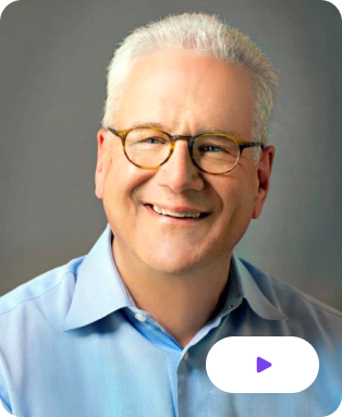 The image shows the thumbnail of Geoffrey Moore, an American management consultant, and author known for his work Crossing the Chasm wearing a white shirt and spects.